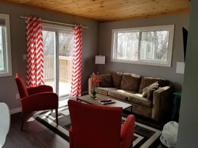 a living room with a couch and a table at Westlake Cottage - Wellington Lodge in Wellington