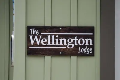 a sign on a wall that reads the wellington lodge at Westlake Cottage - Wellington Lodge in Wellington