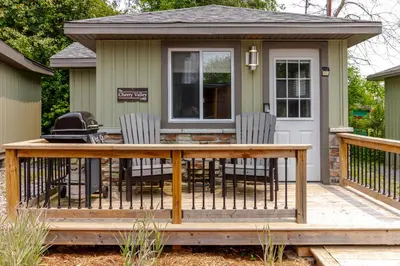 a screened in porch with a table and chairs on a deck at Westlake Cherry Valley Cottage in Wellington