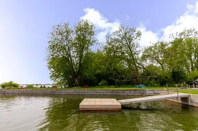a wooden dock in the middle of a body of water at Westlake Cherry Valley Cottage in Wellington