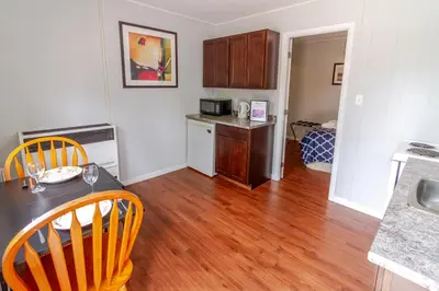 a kitchen with a table and chairs in a room at Westlake Cherry Valley Cottage in Wellington