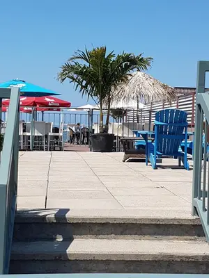 a patio with chairs and umbrellas on the beach at Lakeview Resort Motel in Wasaga Beach