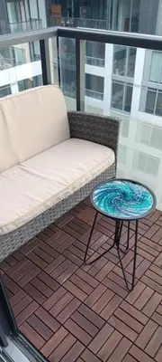 a couch and a table on a balcony at Chic Toronto Blue Jays Getaway in Toronto