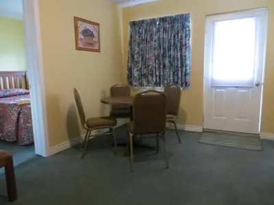 a room with a table and chairs and a window at Villa Nova Motel in Wasaga Beach