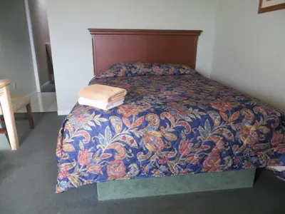 a bedroom with a bed with a colorful comforter at Villa Nova Motel in Wasaga Beach