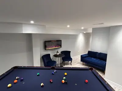 a living room with a pool table and a couch at Whitby Hideout - 3BR, 5BD, 3WR, Pool Table, Sauna in Whitby