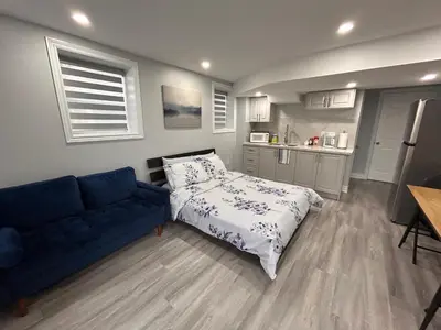 a living room with a bed and a blue couch at Whitby Hideout - 3BR, 5BD, 3WR, Pool Table, Sauna in Whitby