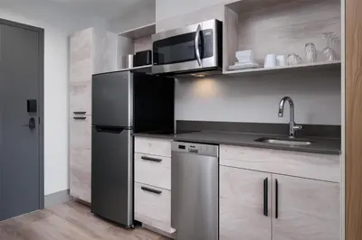 a kitchen with a stainless steel refrigerator and a microwave at @HOME by Best Western Walkerton in Walkerton