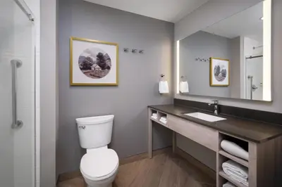 a bathroom with a toilet and a sink and a mirror at @HOME by Best Western Walkerton in Walkerton