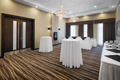 a conference room with white tables and chandeliers at @HOME by Best Western Walkerton in Walkerton