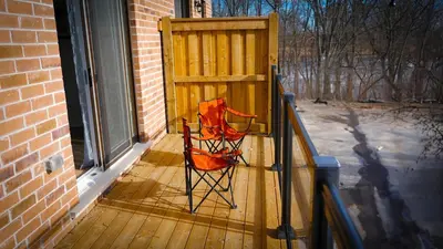 a red chair sitting on a wooden deck at Newly Built 3 plus 1 bedroom Ravine lot Townhouse, Brampton, Ontario in Brampton