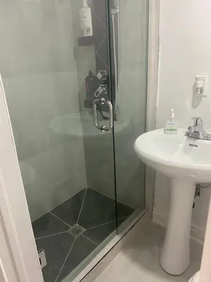 a bathroom with a shower and a sink at 2 bedroom 2 bath separate basement unit in Cambridge