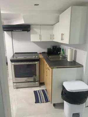 a small kitchen with a sink and a stove at 2 bedroom 2 bath separate basement unit in Cambridge