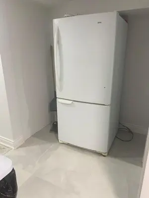 a white refrigerator in a corner of a room at 2 bedroom 2 bath separate basement unit in Cambridge