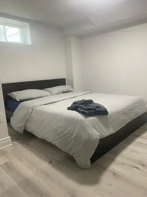 a bedroom with a bed with a robe on it at 2 bedroom 2 bath separate basement unit in Cambridge
