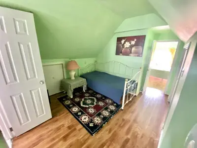 a small room with a bed and a table and a window at Cozy 1 bedroom 4 mins to falls in Niagara Falls