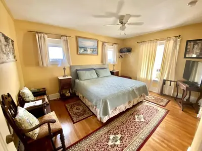 a bedroom with a bed and a chair and windows at Two bedrooms unit with jacuzzi in Niagara Falls