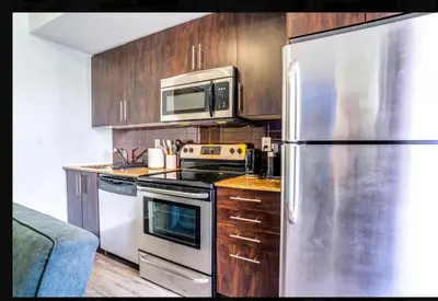 a kitchen with a stainless steel refrigerator and a microwave at Exquisite Living Toronto in Toronto
