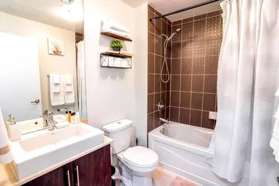 a bathroom with a white toilet and a sink and a tub at Exquisite Living Toronto in Toronto