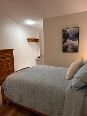 a bedroom with a bed and a dresser at Smokehouse Suites and Stay in Guelph