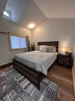 a bedroom with a large bed and a window at Smokehouse Suites and Stay in Guelph