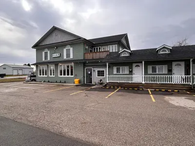 a large building with a parking lot in front of it at Smokehouse Suites and Stay in Guelph