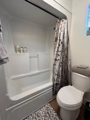 a bathroom with a toilet and a shower curtain at Smokehouse Suites and Stay in Guelph