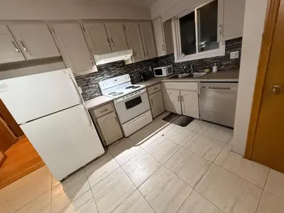 a kitchen with white cabinets and a white refrigerator at STAY AT FLAT CAD 39- Next to Airport, Transit, Park in Kitchener