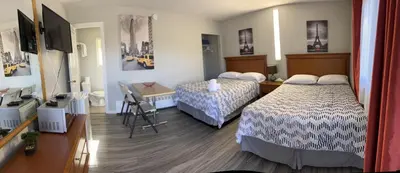 a hotel room with two beds and a television at Wasaga Motel Inn in Wasaga Beach
