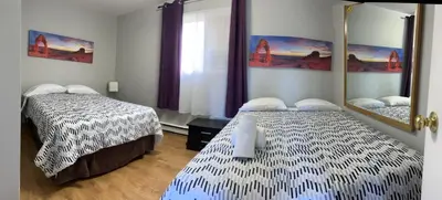 a bedroom with two beds and a mirror at Wasaga Motel Inn in Wasaga Beach