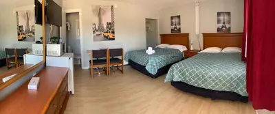 a hotel room with two beds and red curtains at Wasaga Motel Inn in Wasaga Beach