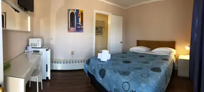 a small room with a bed and a desk at Wasaga Motel Inn in Wasaga Beach