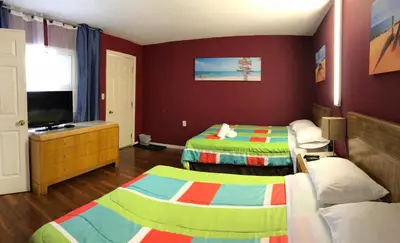 a childrens bedroom with two beds and a television at Wasaga Motel Inn in Wasaga Beach