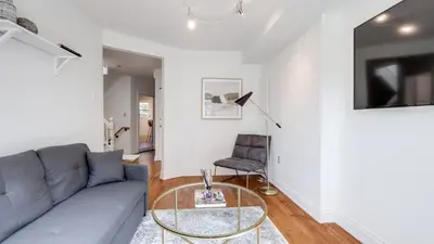 a living room with a gray couch and a glass table at Urban Oasis, 3-Bedroom Apartment at Prime Location in Toronto