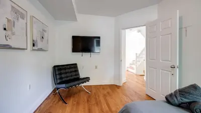 a living room with a black chair and a television at Urban Oasis, 3-Bedroom Apartment at Prime Location in Toronto