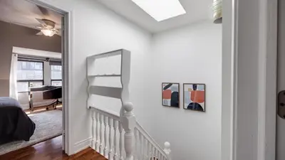 a white room with a staircase and a mirror at Urban Oasis, 3-Bedroom Apartment at Prime Location in Toronto