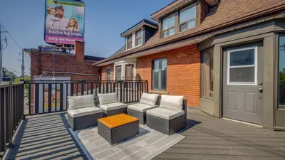 a deck with two chairs and a bench on a house at Urban Oasis, 3-Bedroom Apartment at Prime Location in Toronto