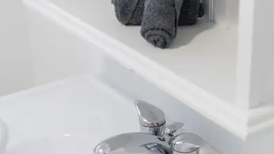 a bathroom sink with a faucet and a towel at Urban Oasis, 3-Bedroom Apartment at Prime Location in Toronto