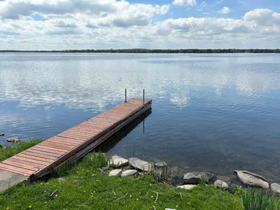 a wooden dock in the middle of a large lake at Waterfront Cottage Near Toronto Private Dock, Water Crafts, BBQ Wi-Fi - Sleeps 4 in Manvers
