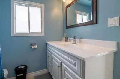a bathroom with a white sink and a mirror at Waterfront Cottage Near Toronto Private Dock, Water Crafts, BBQ Wi-Fi - Sleeps 4 in Manvers