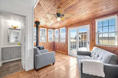 a living room with two chairs and a ceiling fan at Vintage 8BR Farmhouse With Hot Tub Spacious Yard in Port Colborne