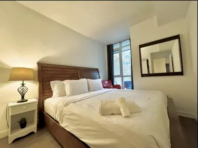 a bedroom with a large white bed with a mirror at KingBed & Bunkbed & Terrace in Toronto