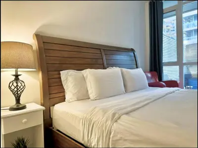a bedroom with a bed and a lamp and a window at KingBed & Bunkbed & Terrace in Toronto