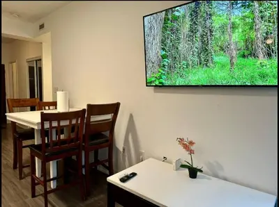 a living room with a table and a television on the wall at KingBed & Bunkbed & Terrace in Toronto