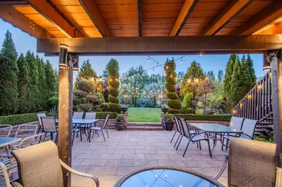 an outdoor patio with tables and chairs and trees at Richmond Hill Ravine Retreat in Richmond Hill