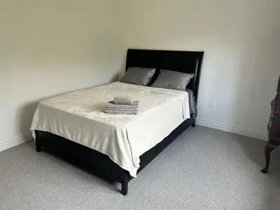 a bed with a black frame and white sheets and pillows at The Angus Nest in Angus