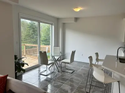 a living room with a table and chairs and a balcony at The Angus Nest in Angus