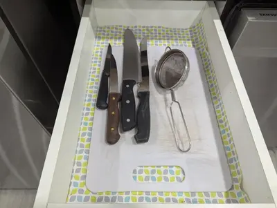 a cutting board with a bunch of kitchen utensils on it at Basement two Queen beds and one single with two full washrooms by YKF airport in Kitchener
