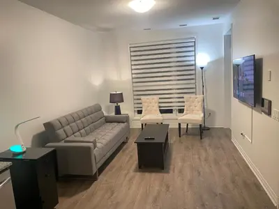 a living room with a couch and two chairs at Executive Luxury Apartment in Oakville