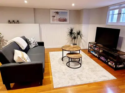 a living room with a couch and a table at Charming Basement Studio Bathroom Full Kitchen in Toronto